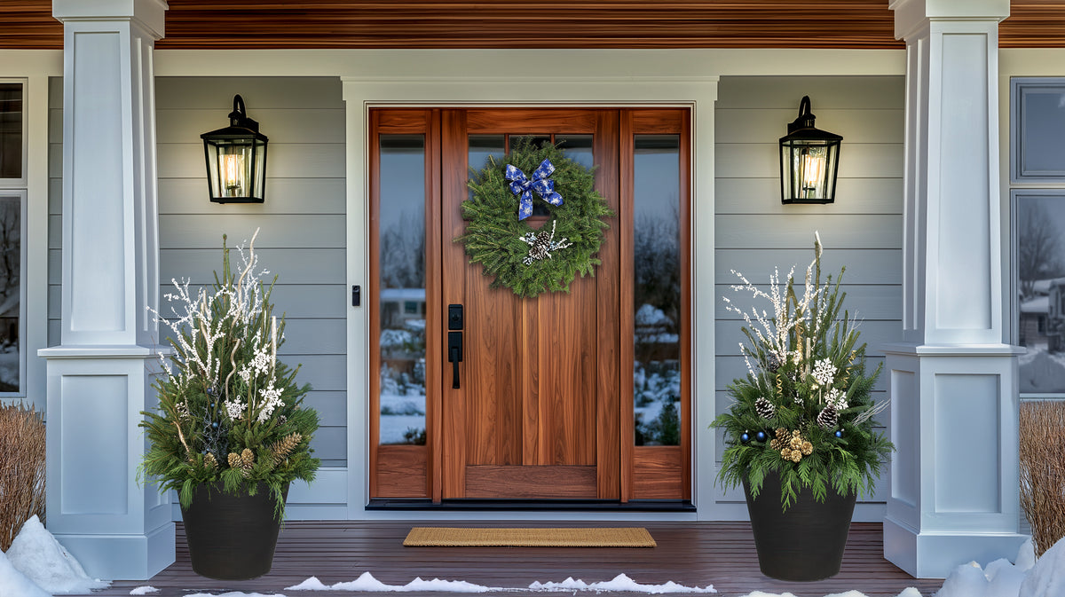 Front door of a house with decorative wreath and plants on a snowy day
